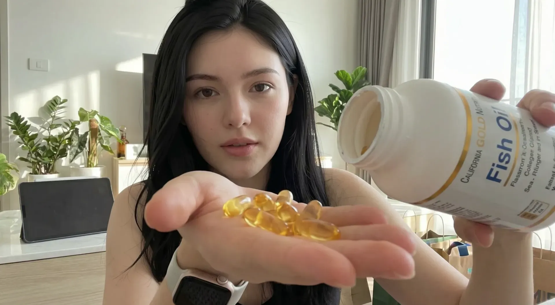 The uploaded reference character sheet shall be used for creating a person or character in this image, Modern Gen-Z Lifestyle Reviewer & Smart Shopper, with reference the Uploaded reference image Character Sheet preserving facial fidelity, 22 year old Bangkokian, demonstrating the product usage showing the large golden softgel size on palm, with a text bubble or label saying 'ทดสอบจริง' (Real Test) in Thai, detailed focus, aspect ratio 21:9